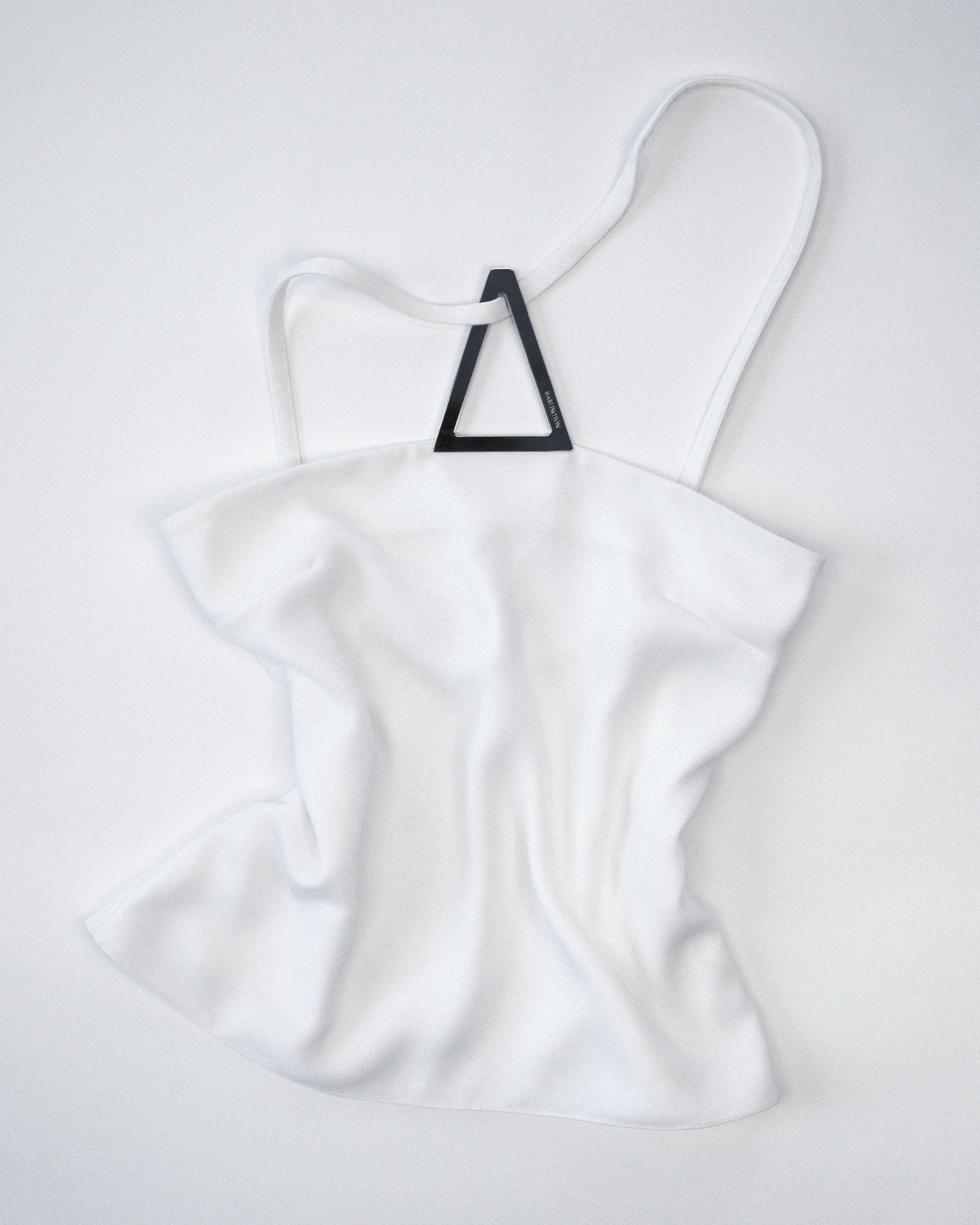 White halter top with a silver metal triangle design on a white background