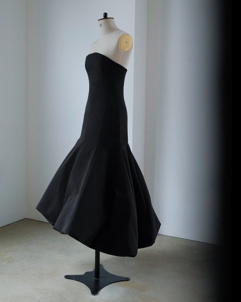 Black strapless dress on a mannequin against a plain background