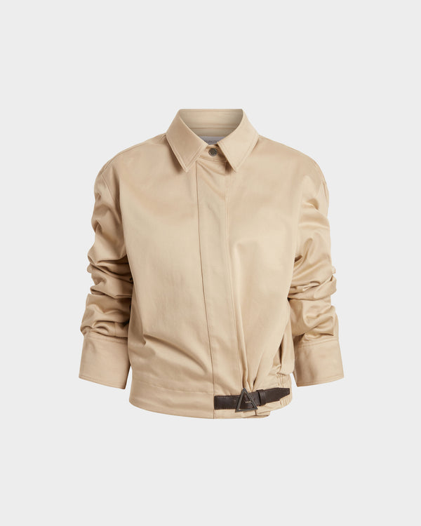 16Arlington Jolie jacket in sand-coloured cotton sateen, featuring a cropped silhouette with a cinched waist, plunging neckline and pointed collar with ruched sleeves and contrast leather buckle. This jacket brings signature tailoring to elevated daytime and evening looks from a luxury British designer brand.