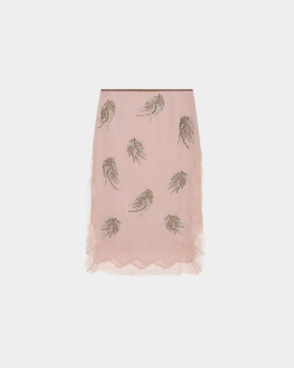 16Arlington Liri skirt in blush pink satin, designed in a midi silhouette finishing at the knee, featuring feather-pattern crystal hot-fix applications and hand-applied lace detailing, finished with a soft suede waistband, ideal for evening styling, occasion wear and statement dressing from a luxury British designer brand.