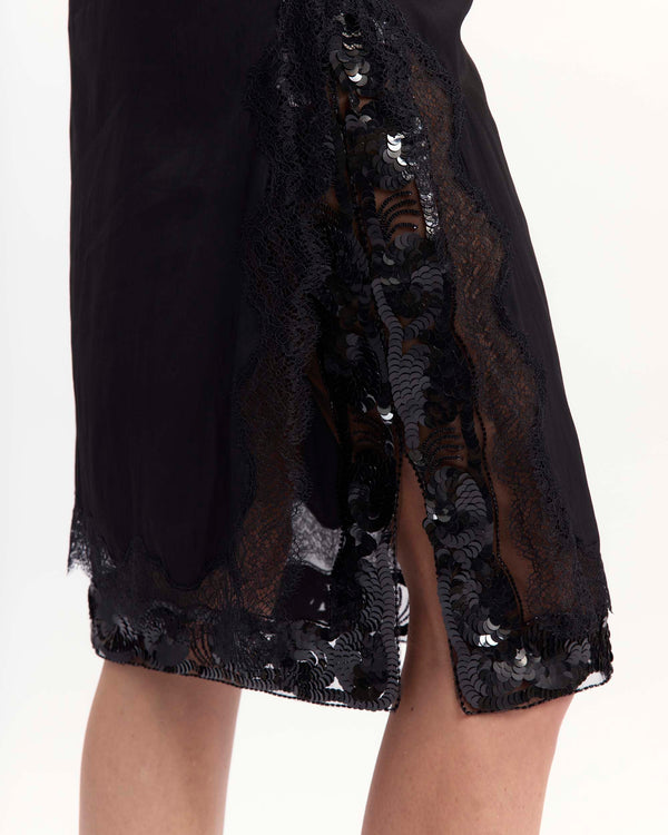 16Arlington Tirso skirt in black satin, designed in a straight silhouette falling just below the knee, featuring scalloped lace trim and a hand-embroidered sequin panel, finished with side split detailing and a tulle lining, ideal for evening styling and occasion wear from a luxury British designer brand. - close-up