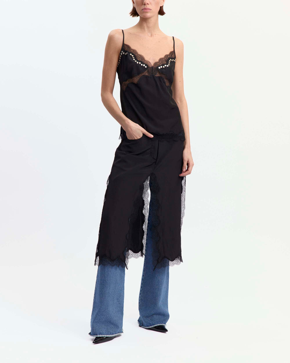16Arlington Clio top in black satin, designed in a minimal slimline silhouette with a V-shaped neckline and adjustable straps, featuring hand-applied scalloped lace inserts, finished with silver rivet detailing at the front and back and a branded metal plaque, ideal for evening styling and elevated everyday dressing from a luxury British designer brand.
