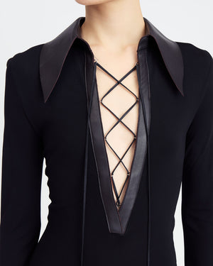 16Arlington Talia midi dress in black smooth jersey with long sleeves, a plunging V-neck framed by dark chocolate leather collar and branded metal-tipped lace-up. Inspired by modern tailoring, this dress is suited to elevated daytime occasions and evening events from a luxury British designer brand. - close-up