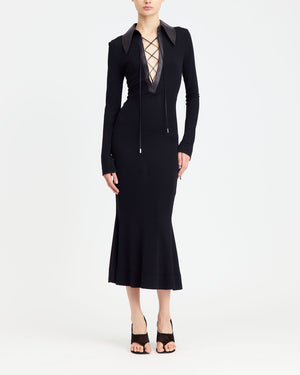 16Arlington Talia midi dress in black smooth jersey with long sleeves, a plunging V-neck framed by dark chocolate leather collar and branded metal-tipped lace-up. Inspired by modern tailoring, this dress is suited to elevated daytime occasions and evening events from a luxury British designer brand. - front view